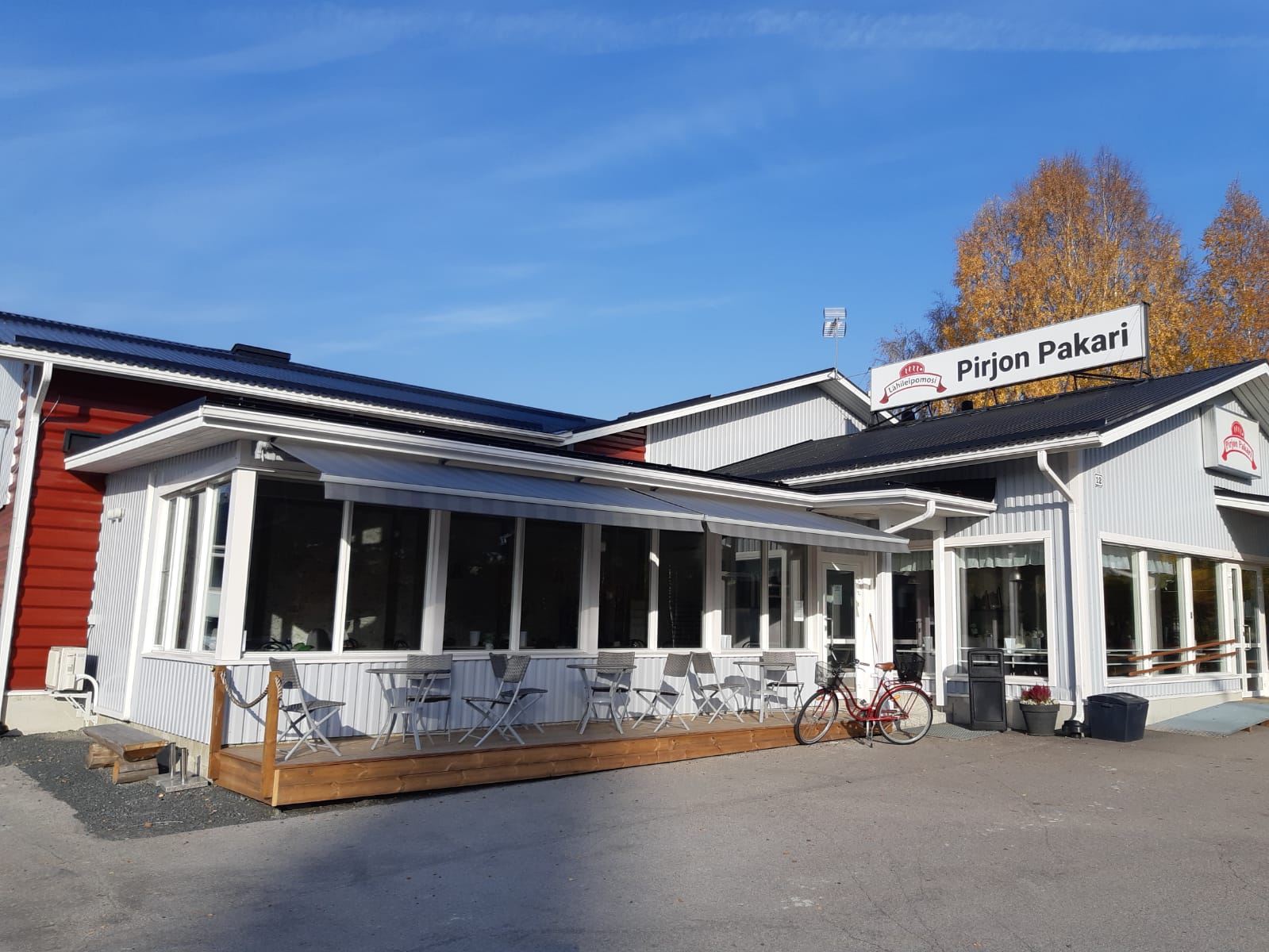 Ravintolan terassi, jonka ylle on asennettu vaaleat markiisit
