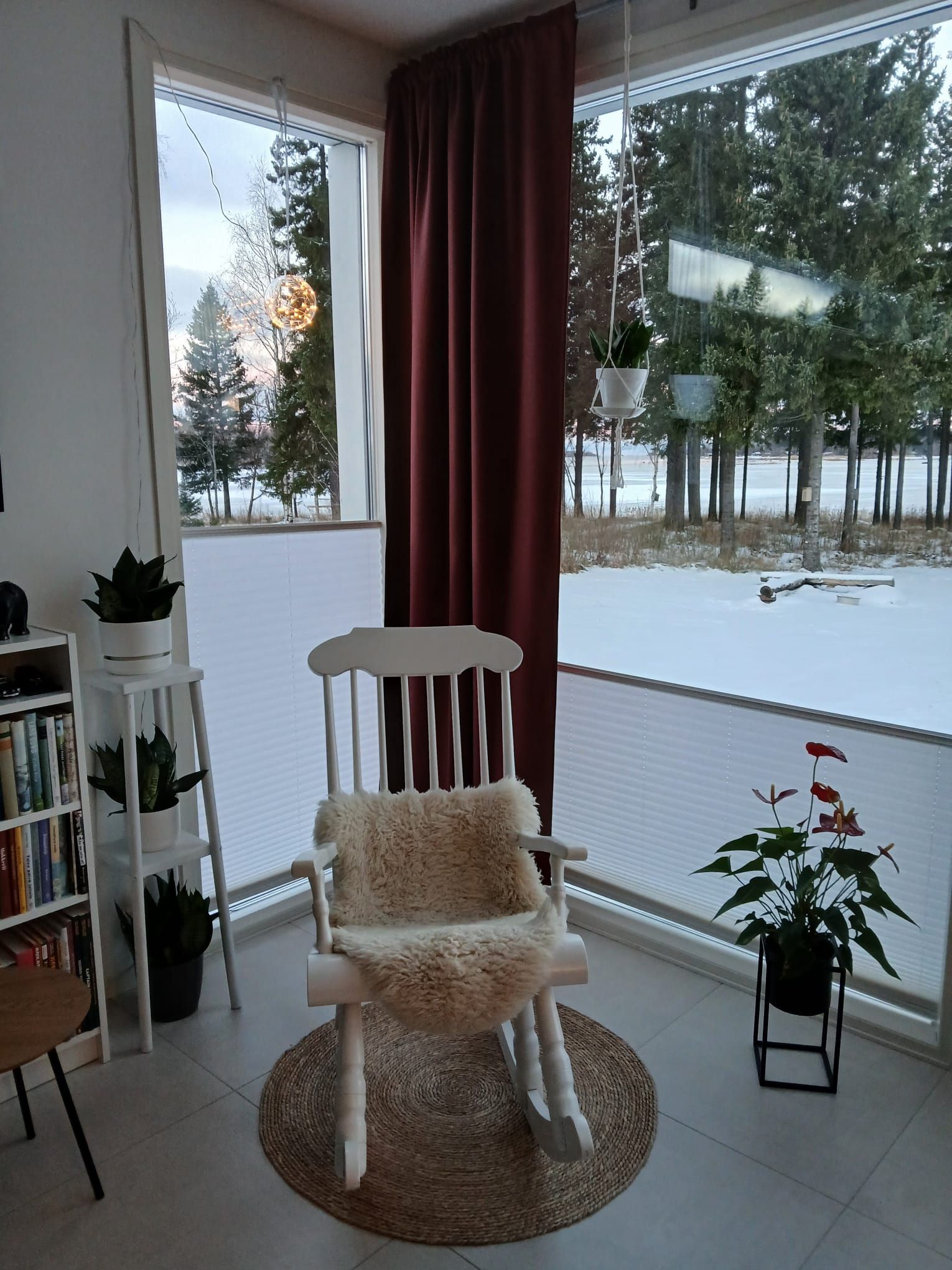 Vekkiverhot olohuoneen suurissa ikkunoissa, ulkona talvinen maisema