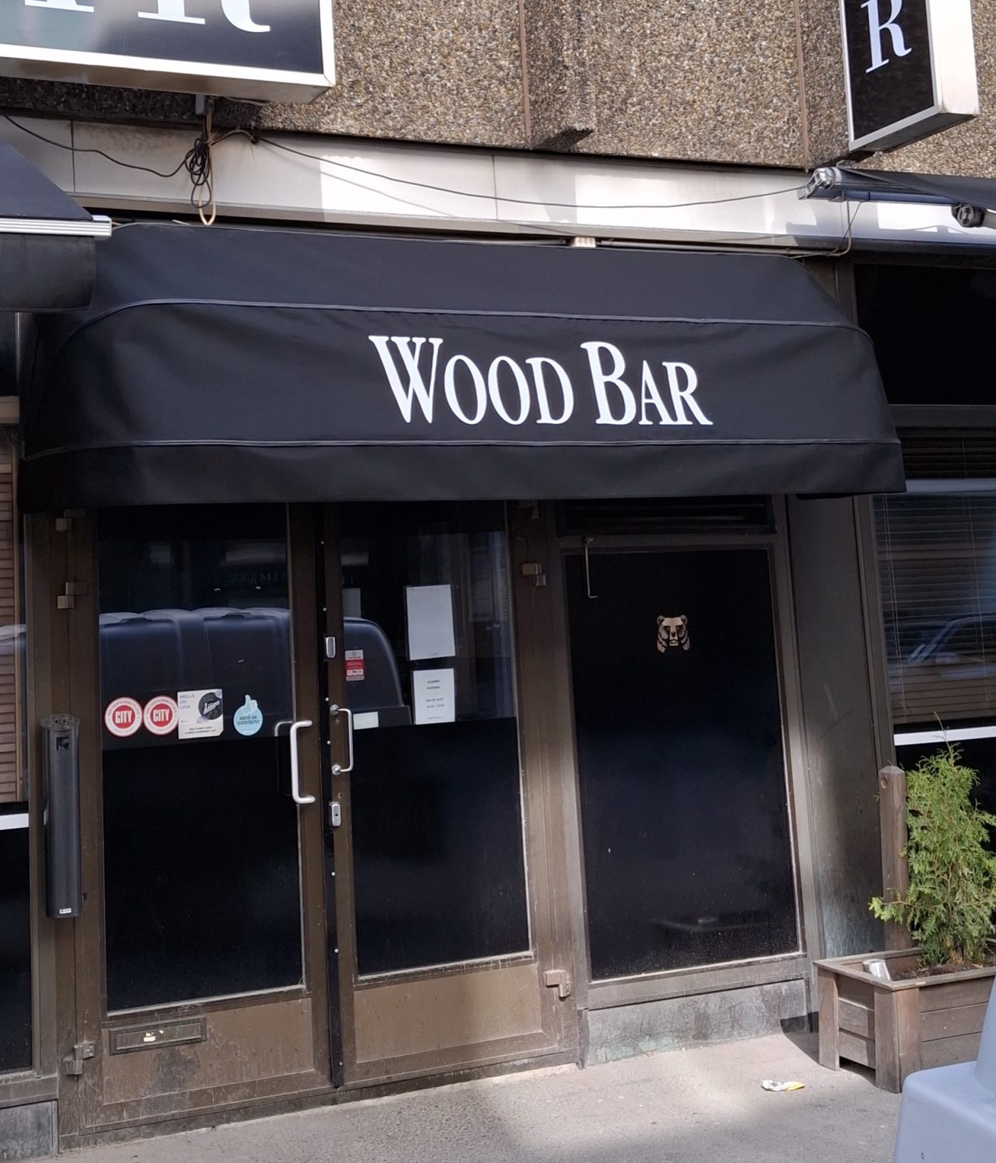 Musta korimarkiisi Wood Bar -tekstillä ravintolan sisäänkäynnin yllä