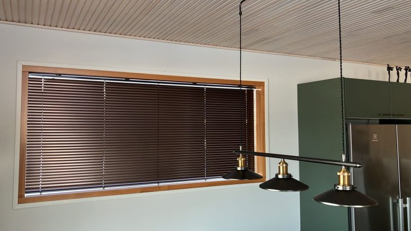 Pronssinsävyinen sälekaihdin keittiön ikkunassa
